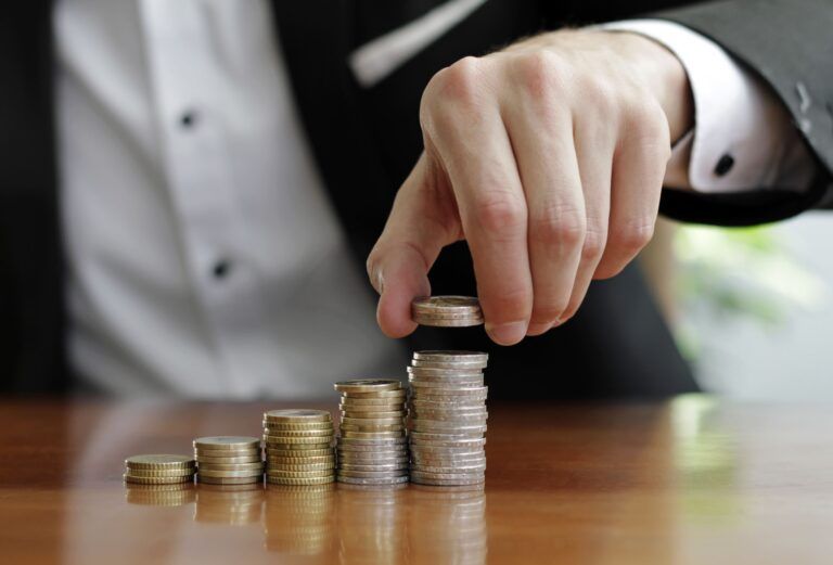 closeup-shot-businessman-s-hands-counting-stacks-coins-after-business-success-1-768x521-2